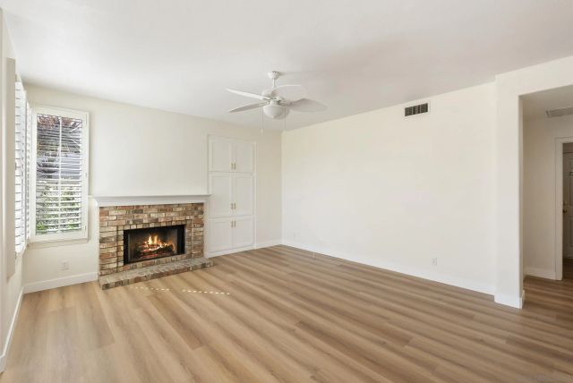 a kitchen with stainless steel appliances granite countertop a refrigerator a sink dishwasher a stove and white countertops with wooden floor