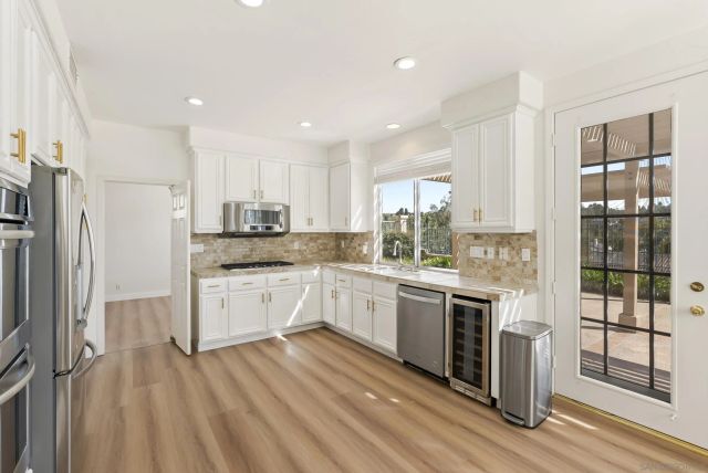 a kitchen with granite countertop white cabinets and a window