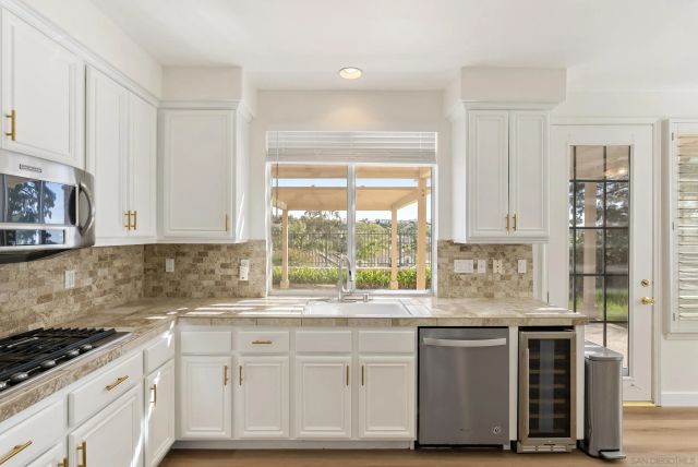 a kitchen with granite countertop a refrigerator and wooden floor