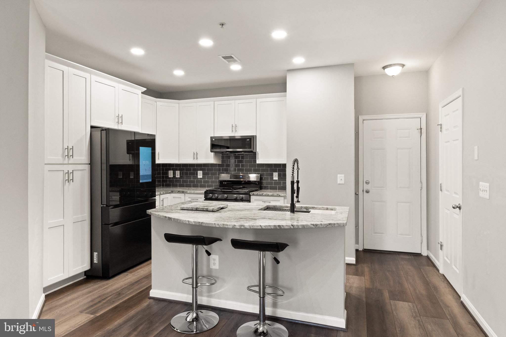 9541 Center Street Manassas, VA 20110 - Photo 13 of 41 a kitchen with kitchen island appliances cabinets and wooden floor