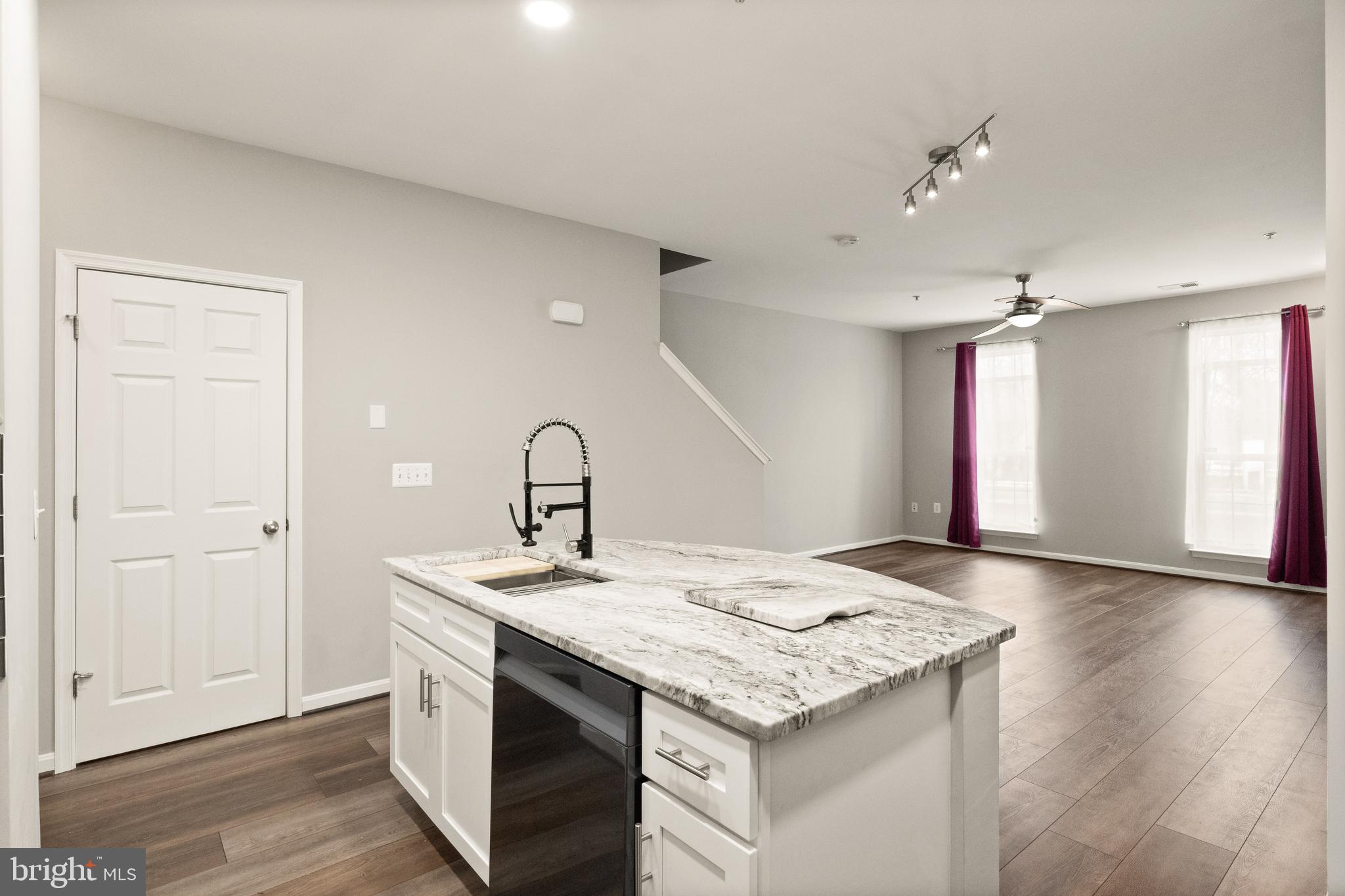 9541 Center Street Manassas, VA 20110 - Photo 16 of 41 a kitchen with granite countertop a sink and dishwasher with wooden floor