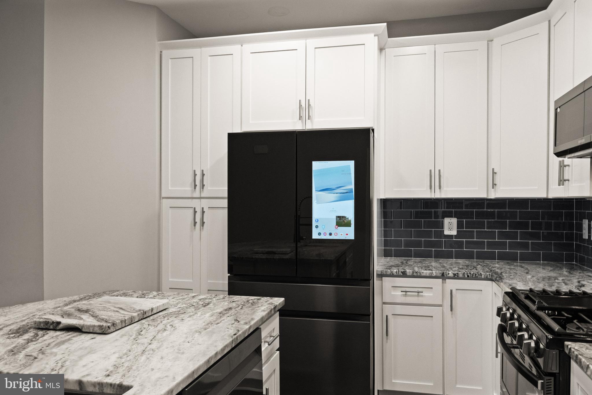 9541 Center Street Manassas, VA 20110 - Photo 17 of 41 a kitchen with granite countertop white cabinets and black appliances