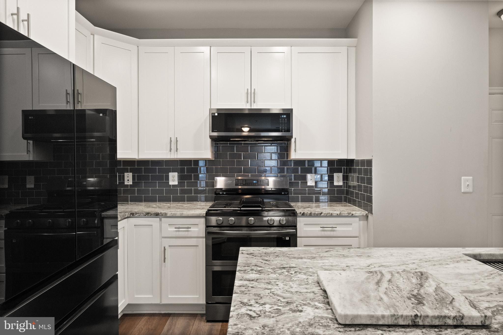 9541 Center Street Manassas, VA 20110 - Photo 3 of 41 a kitchen with granite countertop a stove and a white cabinets