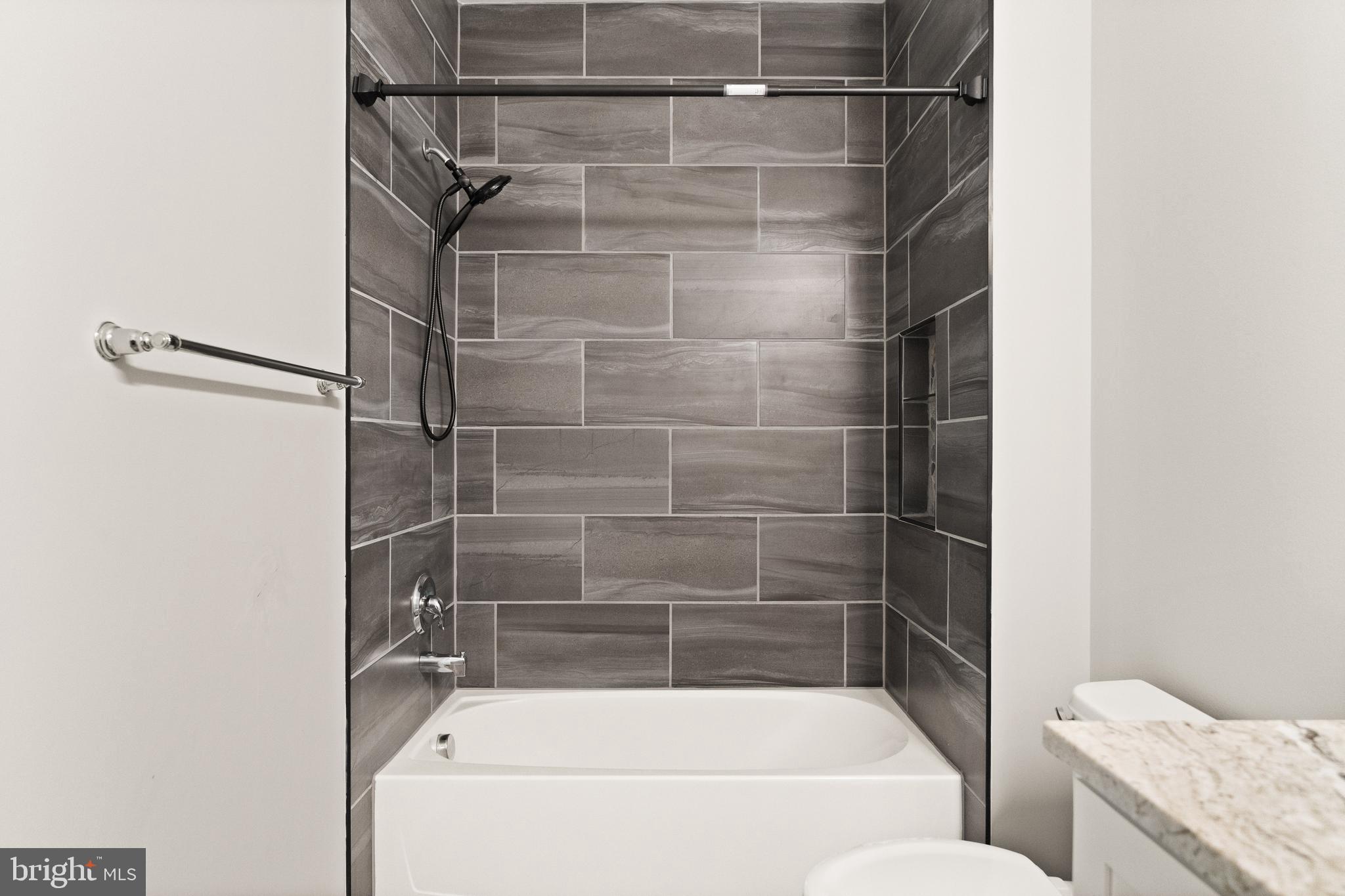 9541 Center Street Manassas, VA 20110 - Photo 35 of 41 a bathroom with a bath tub and a shower