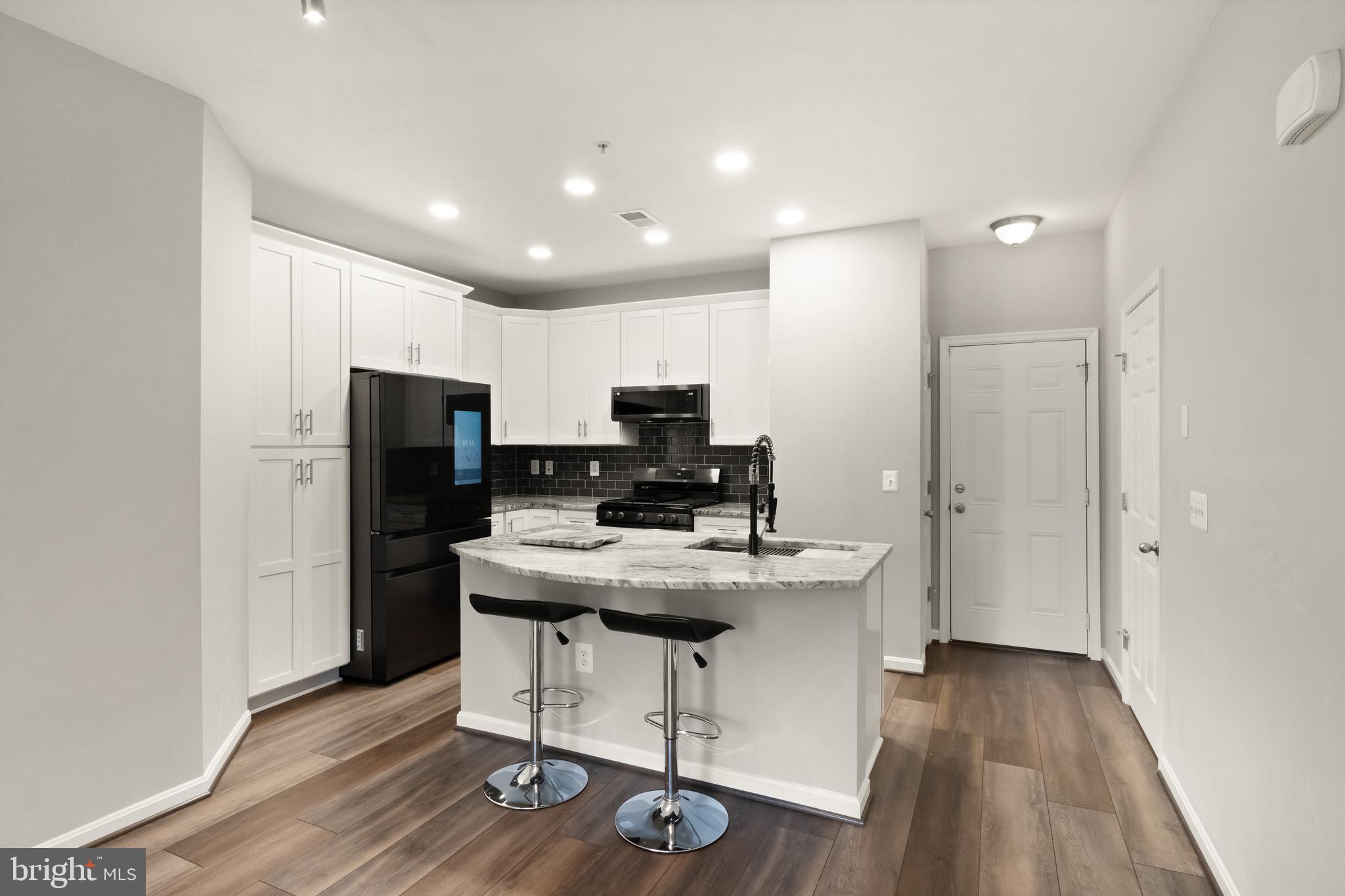 9541 Center Street Manassas, VA 20110 - Photo 5 of 41 a kitchen with kitchen island cabinets stainless steel appliances a sink and a refrigerator