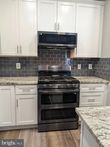 a stove top oven sitting inside of a kitchen