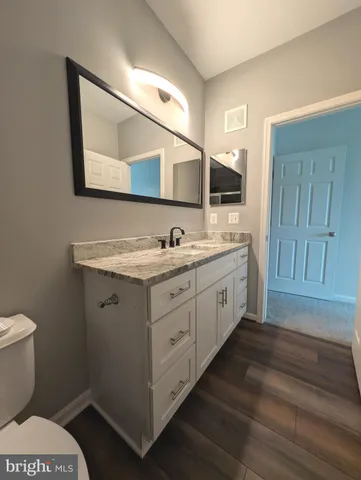 a spacious bathroom with a toilet sink and mirror