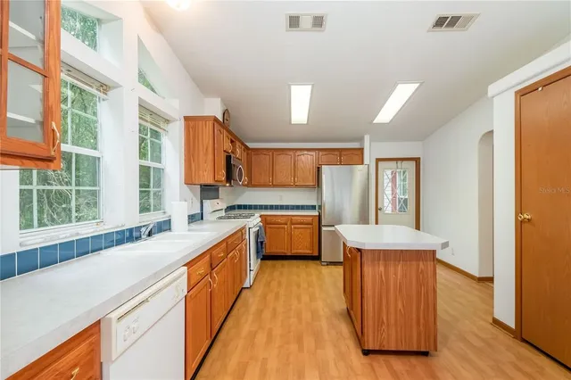 an aerial view of residential houses with outdoor space and trees