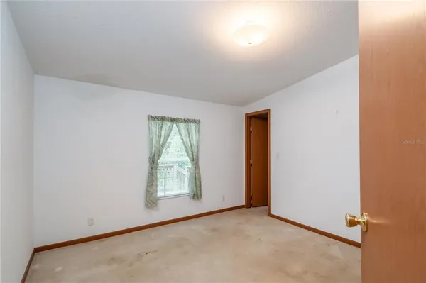 a view of an empty room with a chandelier fan