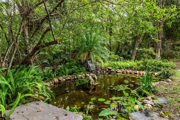 an aerial view of residential houses with outdoor space and trees