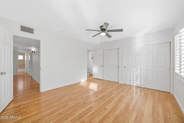 a view of empty room with wooden floor and window