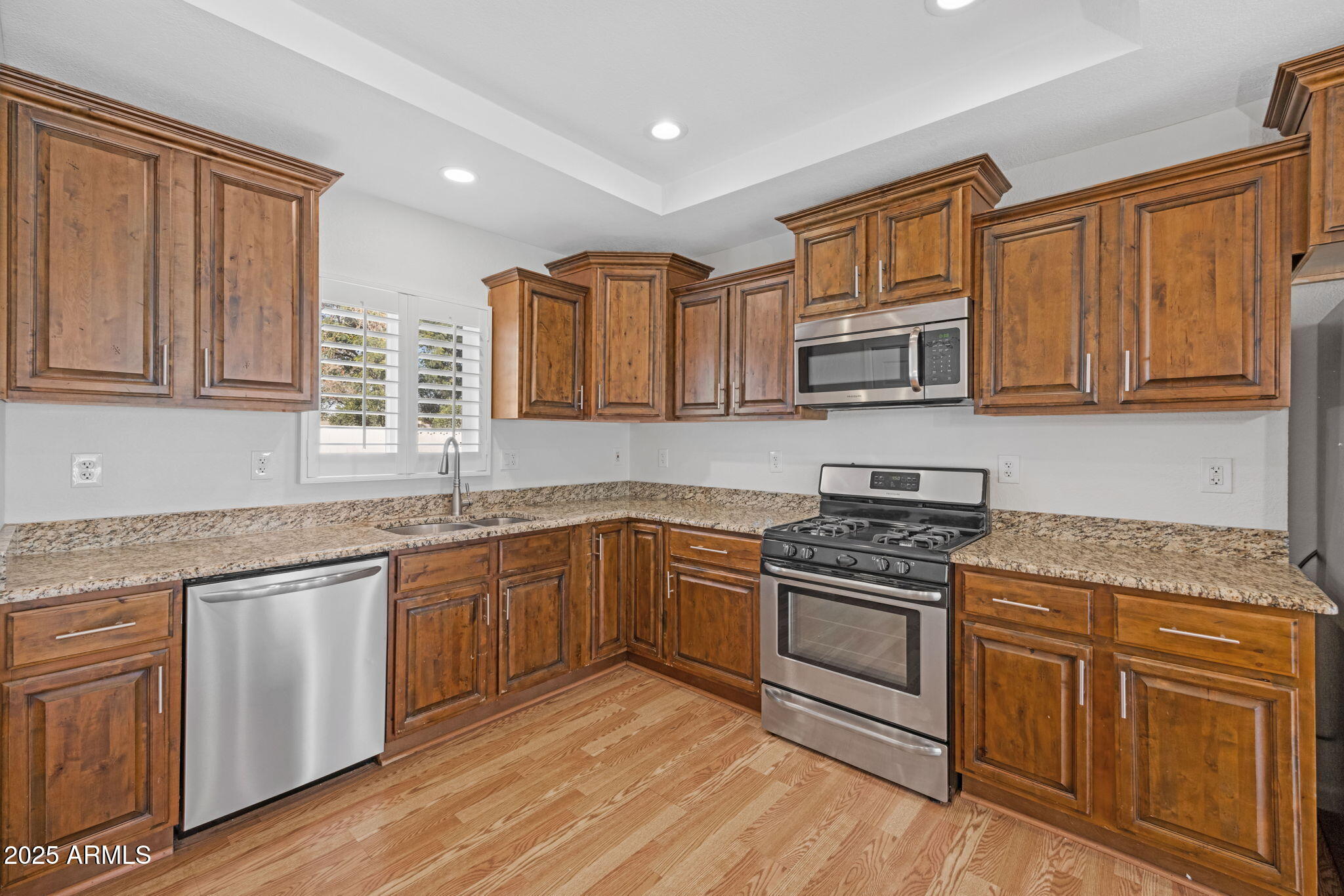 4020 North 44th Place Phoenix, AZ 85018 - Photo 7 of 17 a kitchen with granite countertop wooden cabinets and a stove top oven