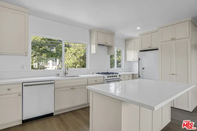 a kitchen with white cabinets and white appliances