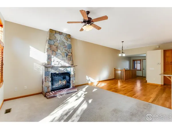 a view of a livingroom with a fireplace and a ceiling fan