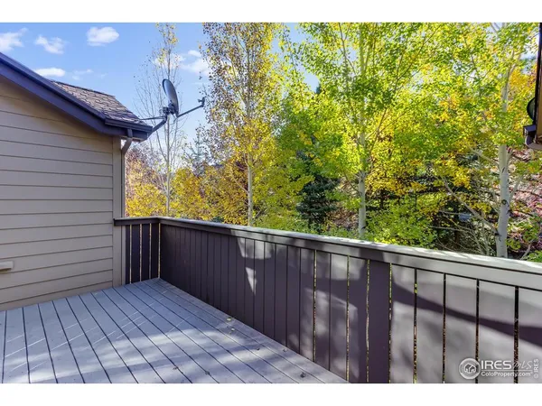 a view of a balcony with wooden floor and fence