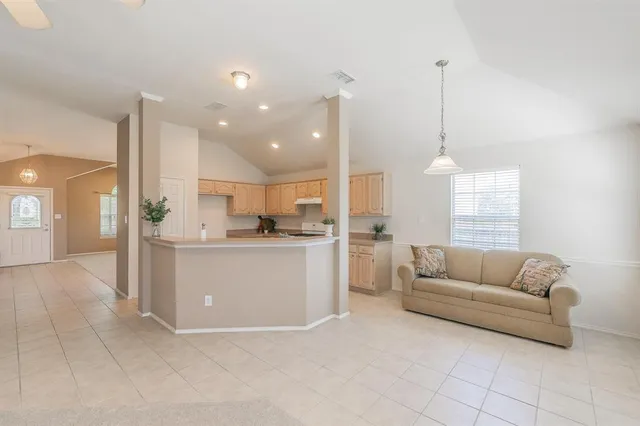 a living room with furniture and kitchen view