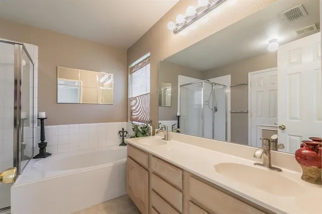 a bathroom with a tub sink and mirror