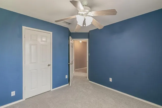 an empty room with a chandelier fan and a chandelier fan
