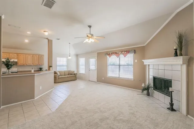 a large white kitchen with a fireplace and a large window
