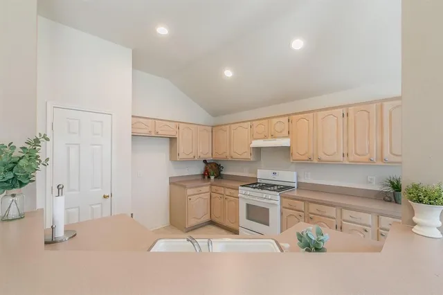 a kitchen with granite countertop a stove sink and cabinets