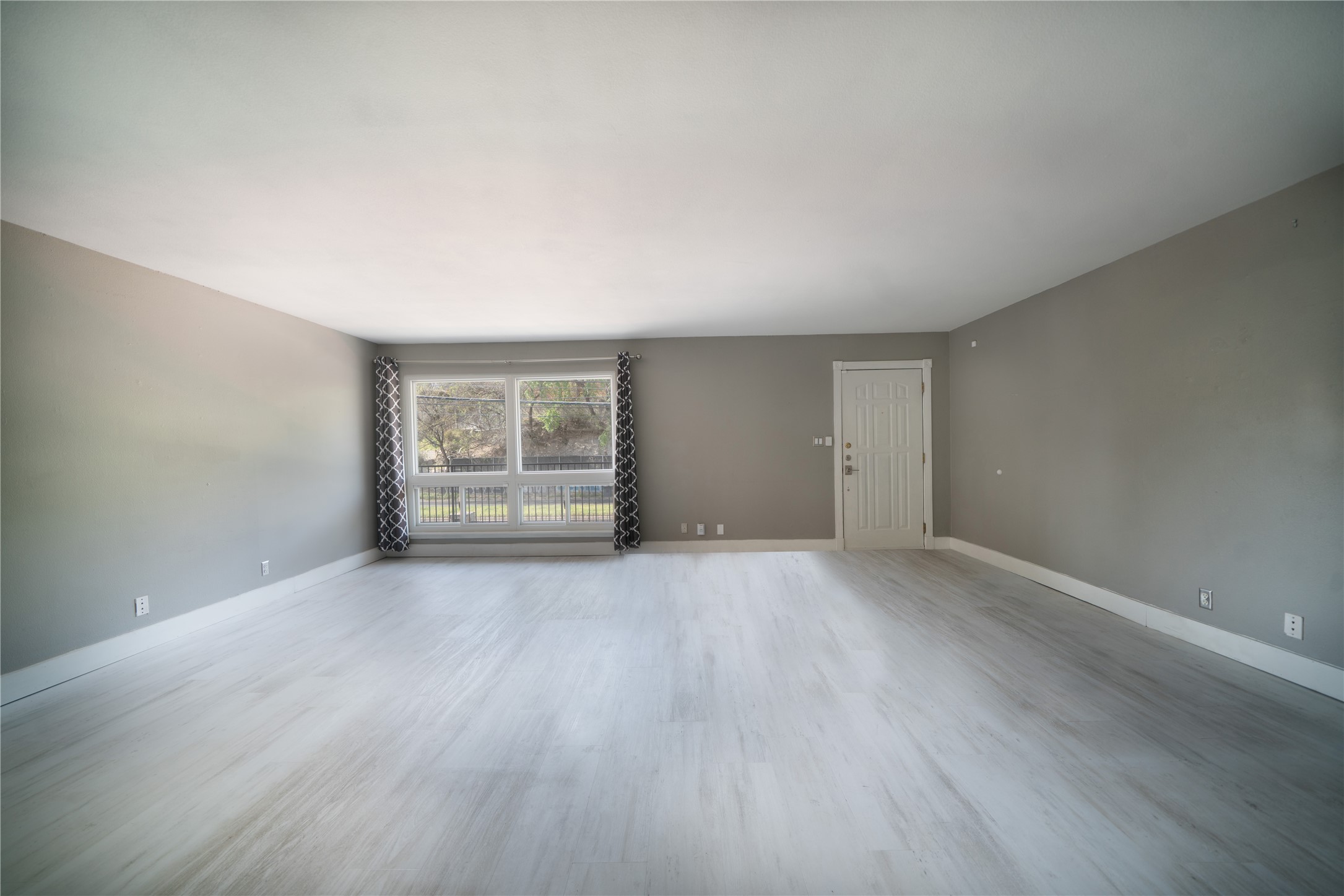 500 East Riverside Drive, Unit 242 Austin, TX 78704 - Photo 5 of 40 Unfurnished living room featuring baseboards and wood finished floors