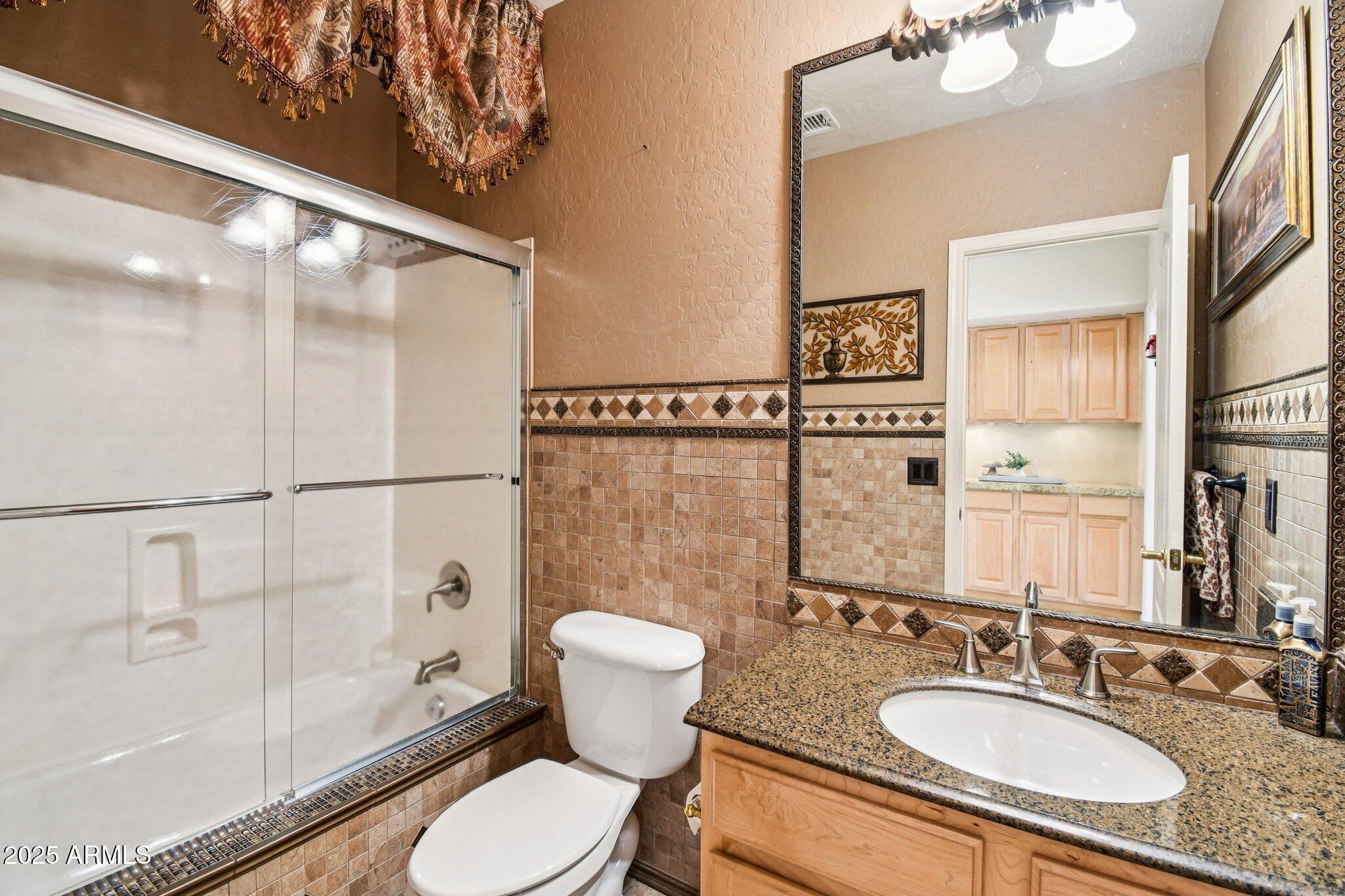 923 West Windsong Drive Phoenix, AZ 85045 - Photo 12 of 57 a bathroom with a granite countertop sink toilet a mirror and shower
