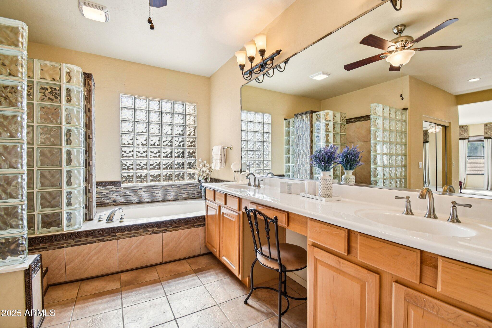 923 West Windsong Drive Phoenix, AZ 85045 - Photo 24 of 57 a spacious bathroom with a double vanity sink a large mirror and a bathtub