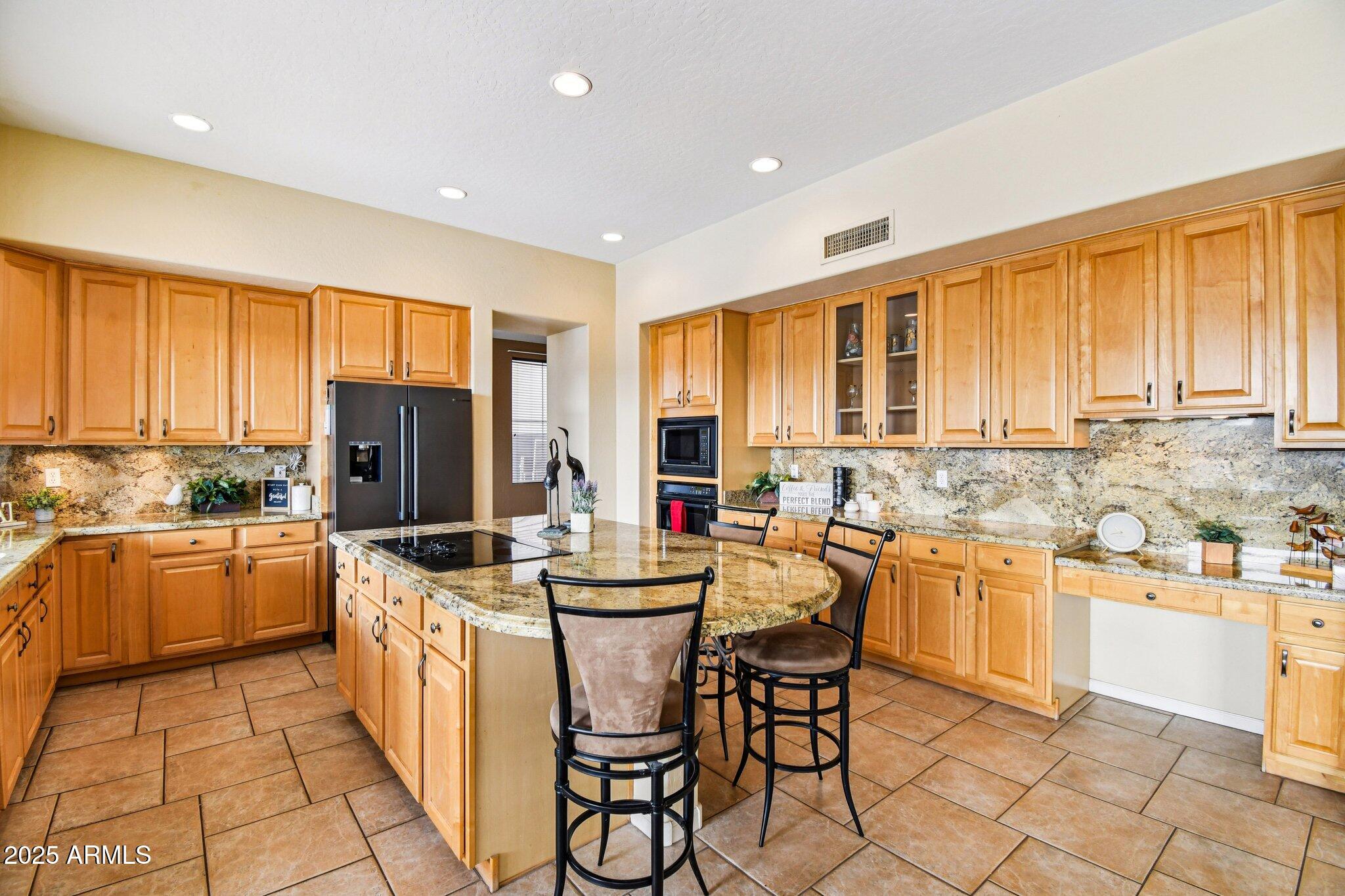 923 West Windsong Drive Phoenix, AZ 85045 - Photo 6 of 57 a kitchen with stainless steel appliances kitchen island granite countertop a sink and cabinets