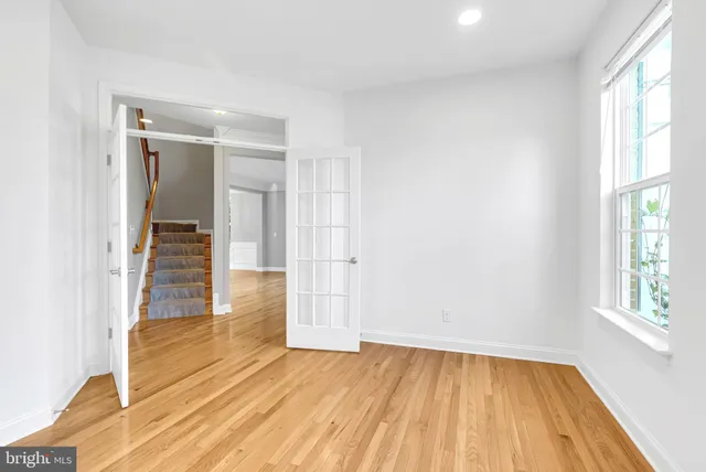 a bedroom with a bed a couch and a large window