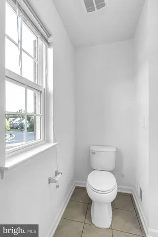 a view of empty room with wooden floor and windows