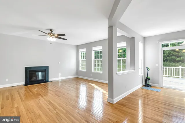 a view of an empty room with window wooden floor and front door