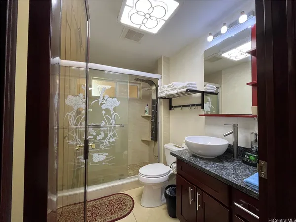 a bathroom with a granite countertop sink toilet a mirror and shower