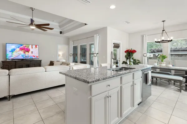 a kitchen with kitchen island granite countertop a sink cabinets and window
