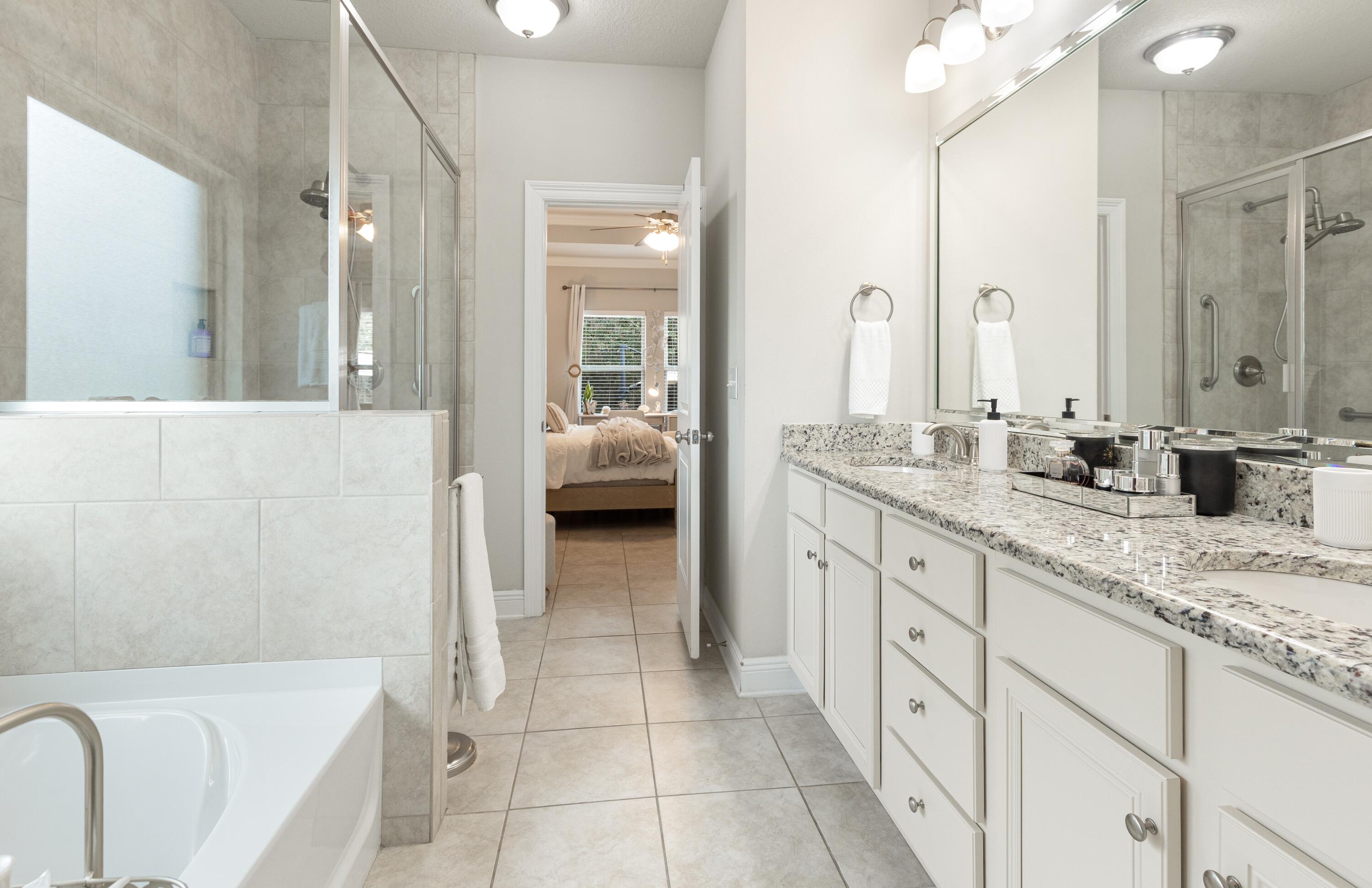114 Maddox Street Santa Rosa Beach, FL 32459 - Photo 18 of 31 a spacious en suite bathroom with a granite countertop tub sink and mirror