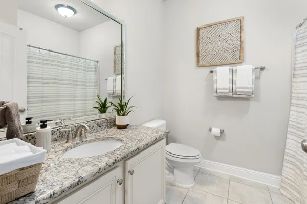 a bathroom with a granite countertop sink a toilet and a mirror