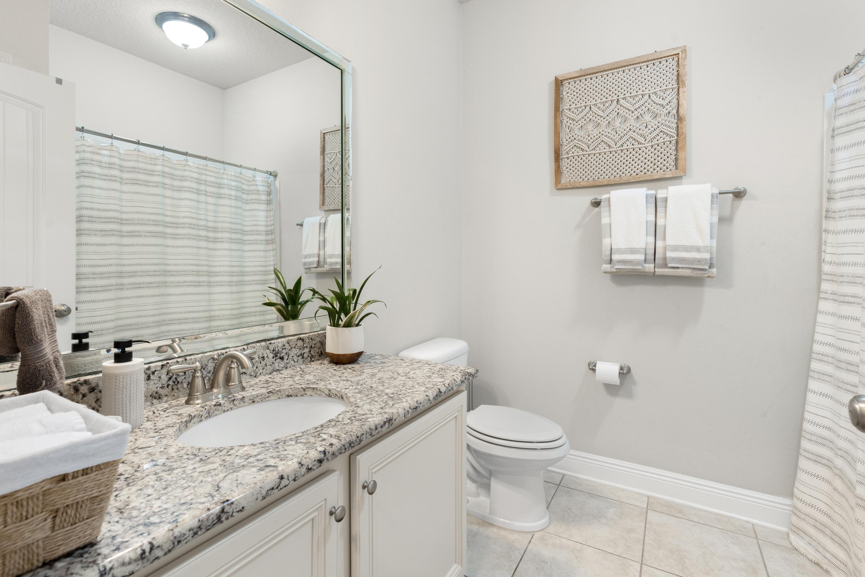114 Maddox Street Santa Rosa Beach, FL 32459 - Photo 21 of 31 a bathroom with a granite countertop sink a toilet and a mirror