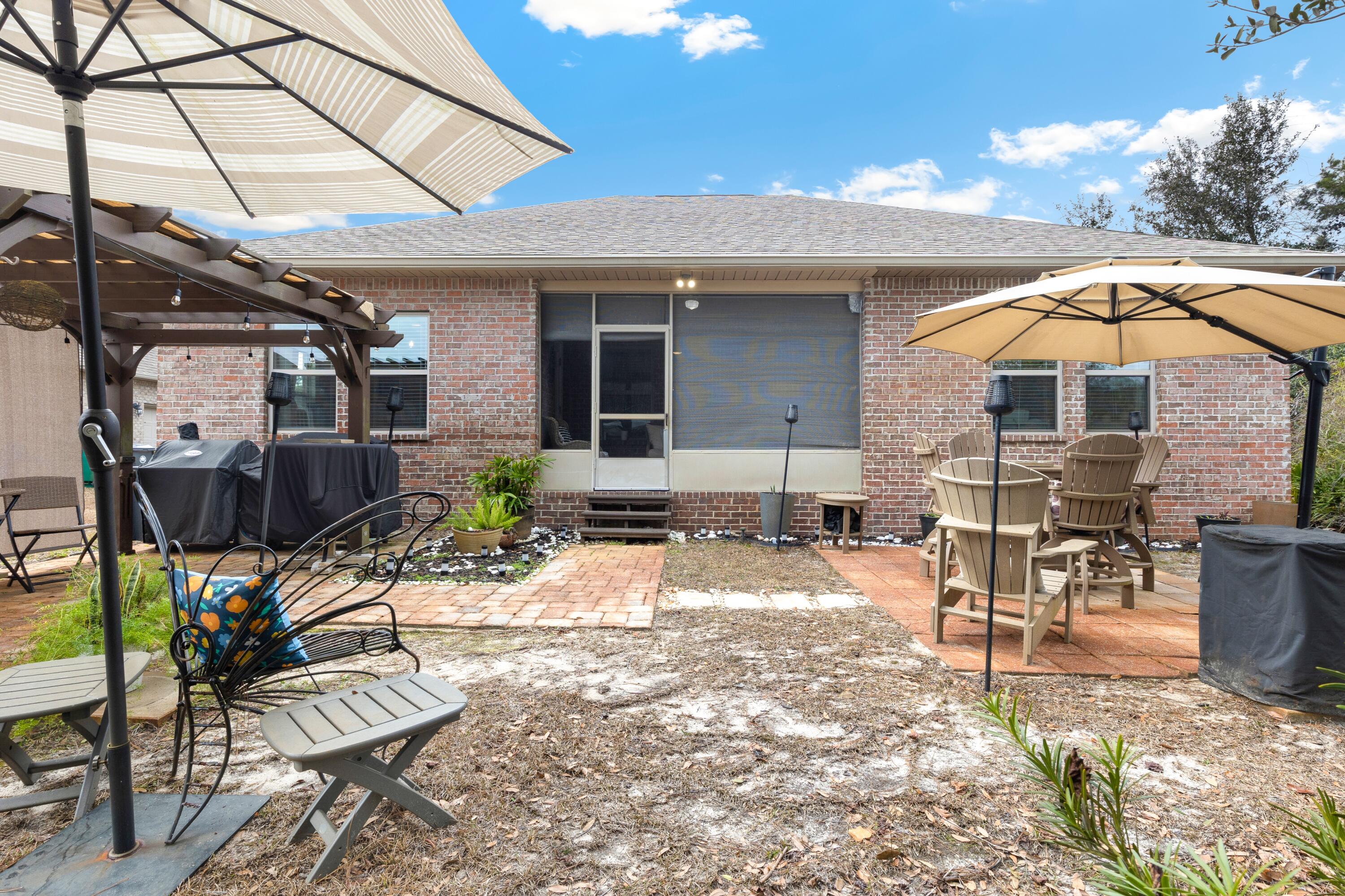 114 Maddox Street Santa Rosa Beach, FL 32459 - Photo 26 of 31 a view of a patio with table and chairs under an umbrella