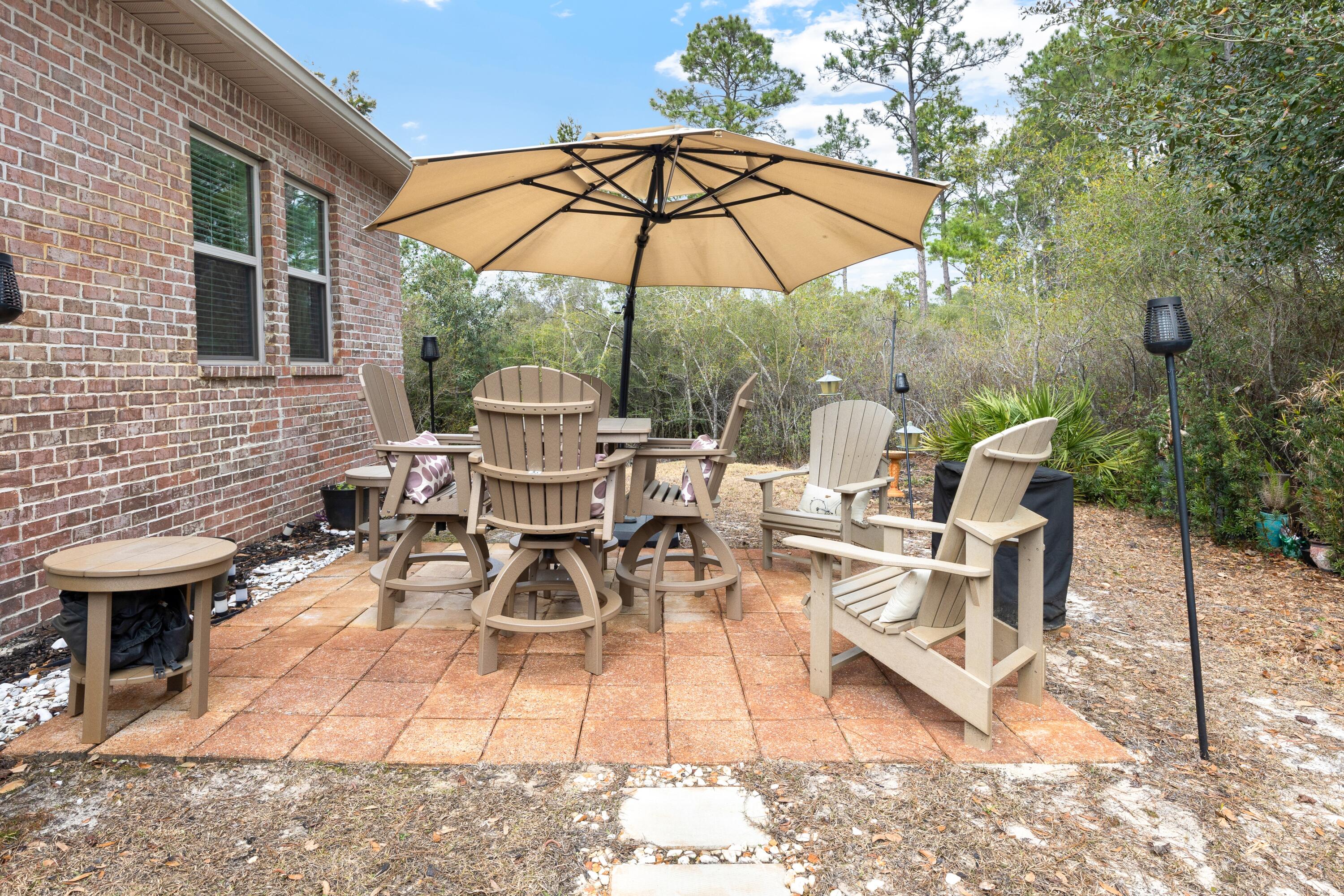 114 Maddox Street Santa Rosa Beach, FL 32459 - Photo 27 of 31 a view of a patio with table and chairs under an umbrella