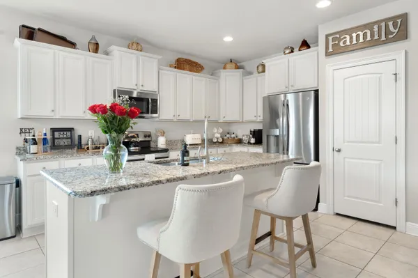 a kitchen with stainless steel appliances granite countertop a white cabinets and a refrigerator