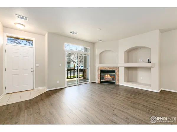 a view of a room with wooden floor and a fireplace