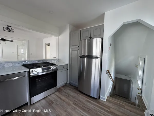 a kitchen with a refrigerator stove and wooden cabinets