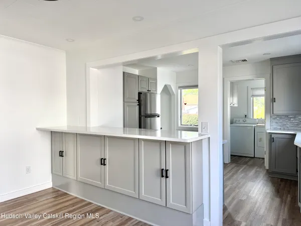a kitchen with a sink and wooden floor