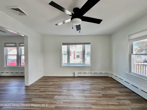 an empty room with wooden floor and windows