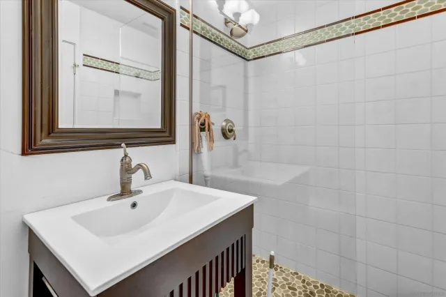 a bathroom with a sink a mirror and shower