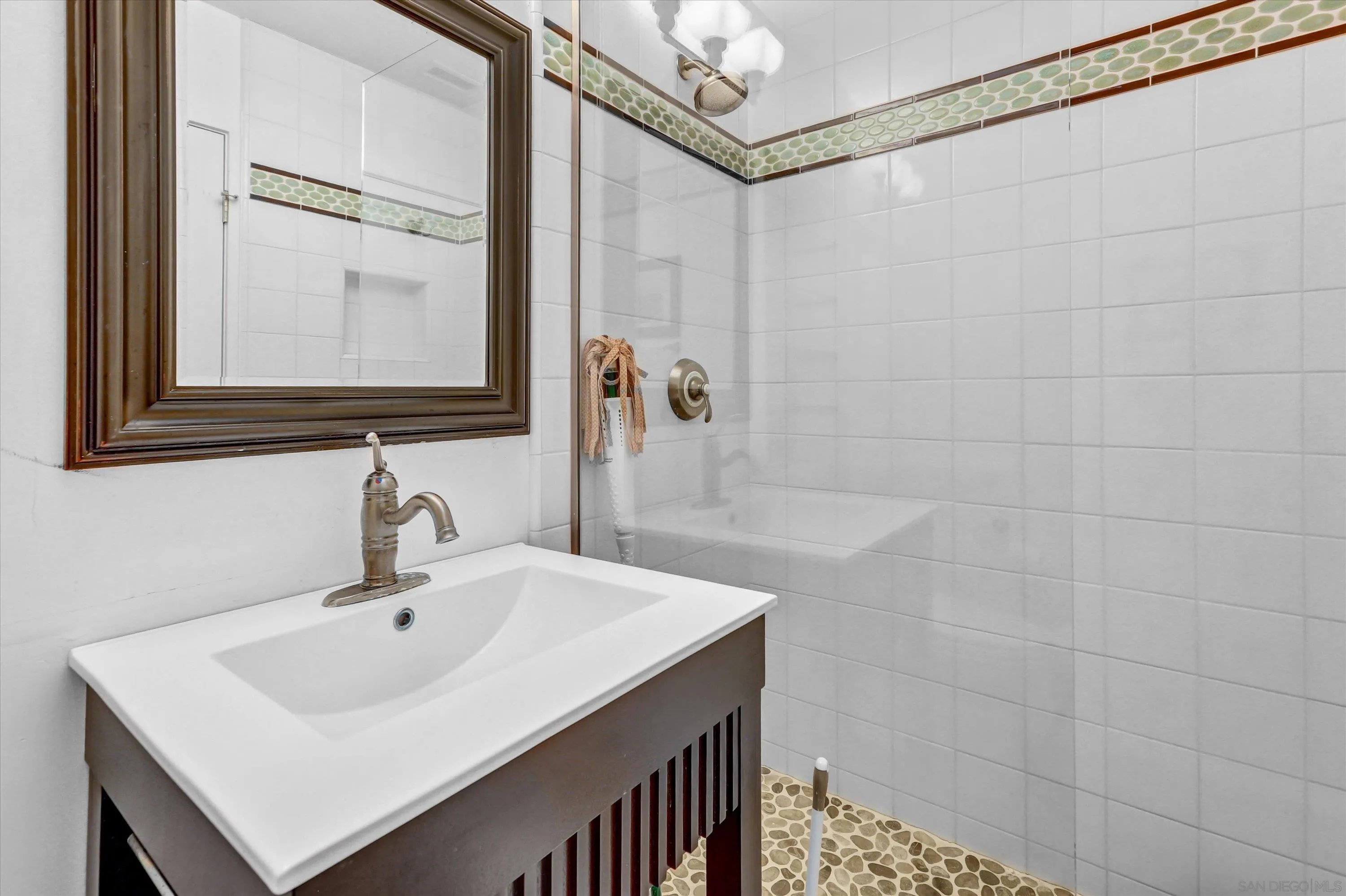 3335 Riviera Drive San Diego, CA 92109 - Photo 12 of 22 a bathroom with a sink a mirror and shower