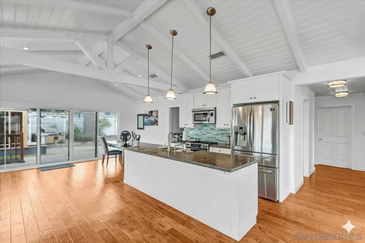 3335 Riviera Drive San Diego, CA 92109 - Photo 5 of 22 a kitchen with stainless steel appliances granite countertop a refrigerator a oven a stove and a sink with cabinets