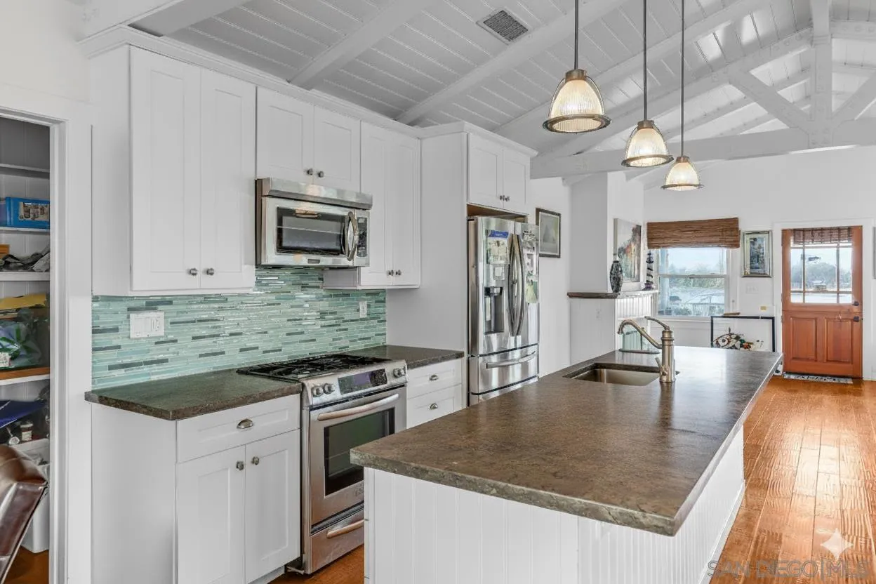 3335 Riviera Drive San Diego, CA 92109 - Photo 6 of 22 a kitchen with granite countertop a stove a sink and a refrigerator