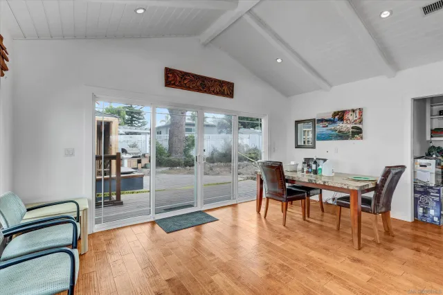 a dining room with furniture a floor to ceiling window and wooden floor