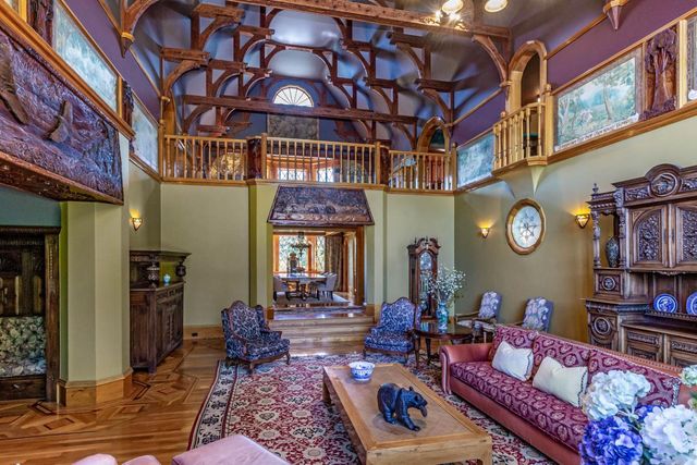 a living room with fireplace furniture and a rug