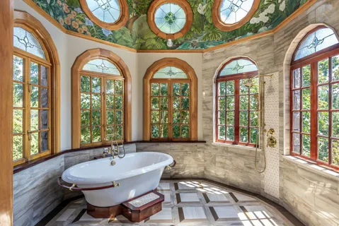 a bathroom with a granite countertop tub and a large window